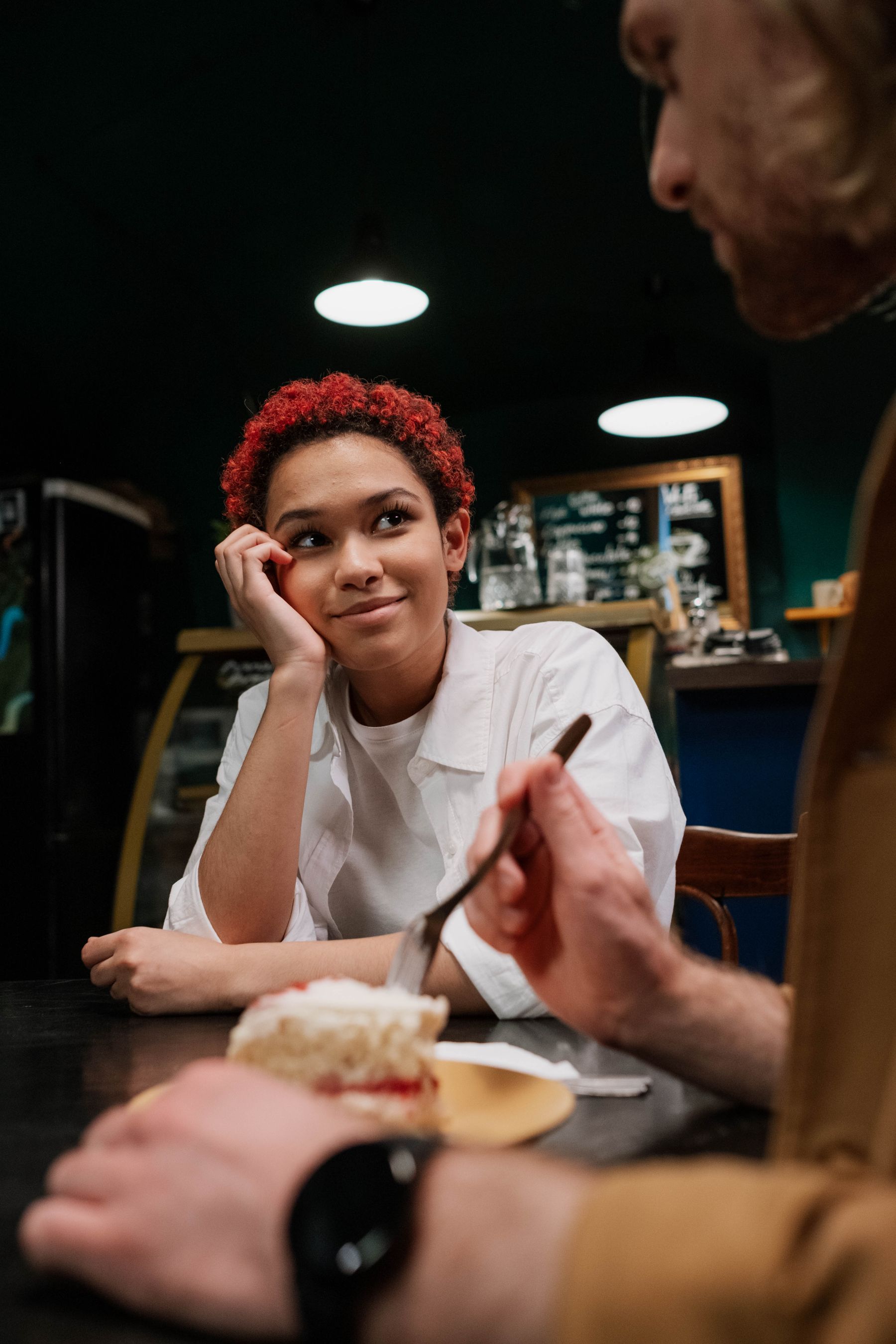 A woman listening to a man across a café table